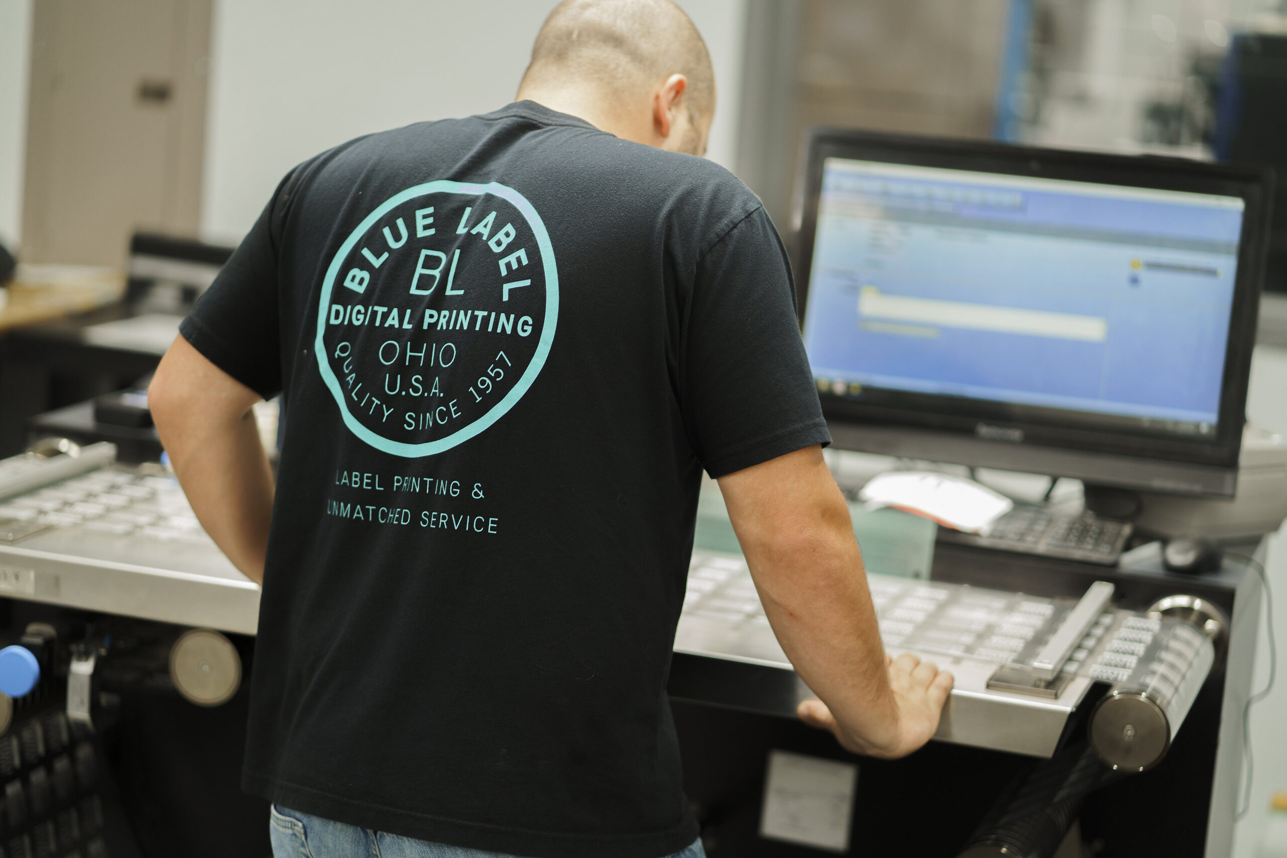 A digital label printing expert looking over labels for bottles.