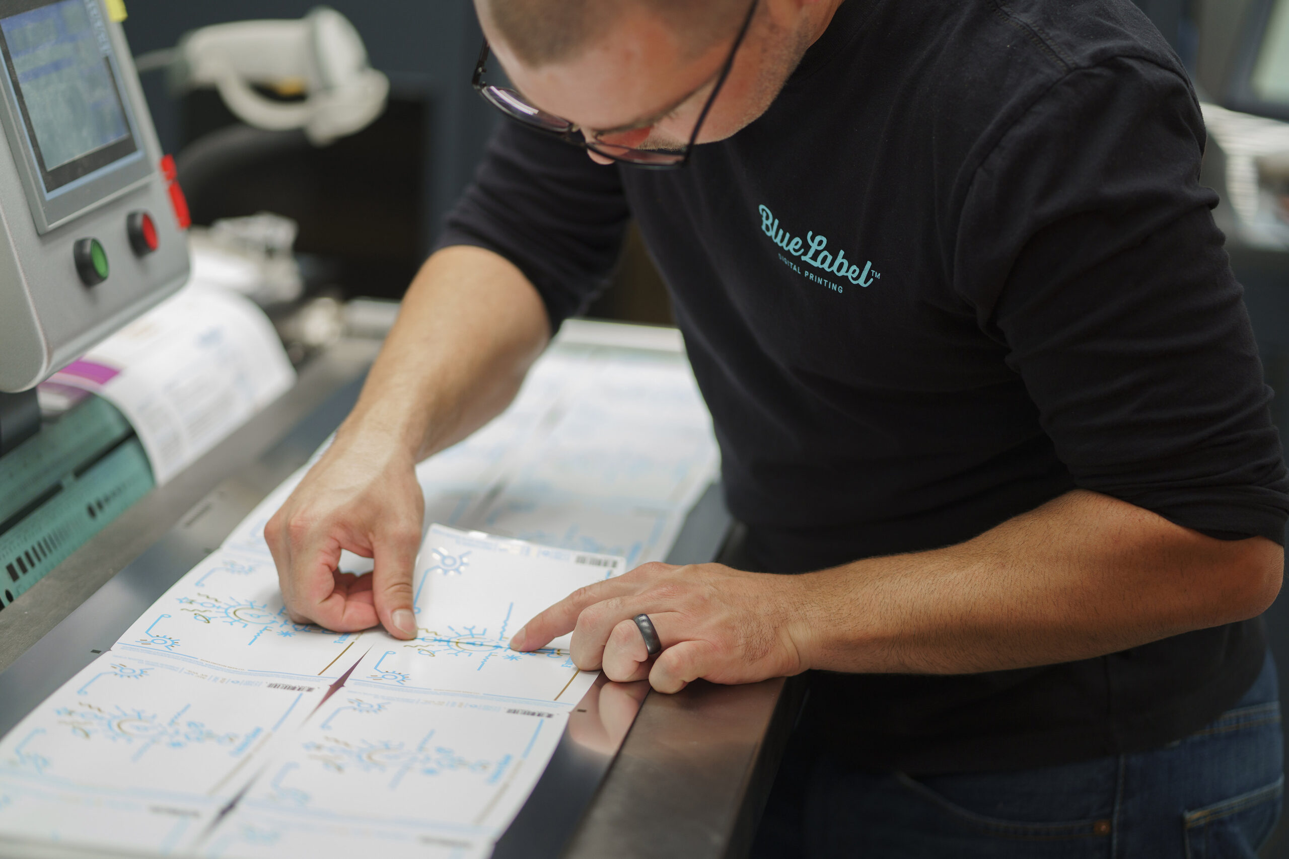 A professional measuring out a label for cannabis products.