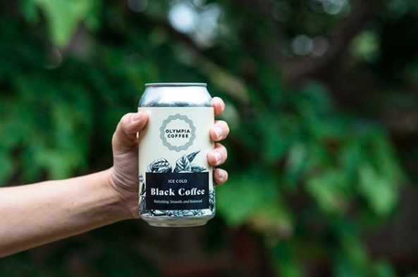 A hand holding a cold brew can with a label.