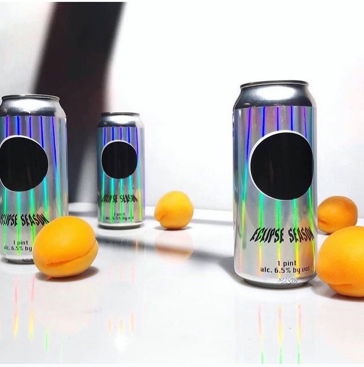A trio of beer cans with holographic labels.