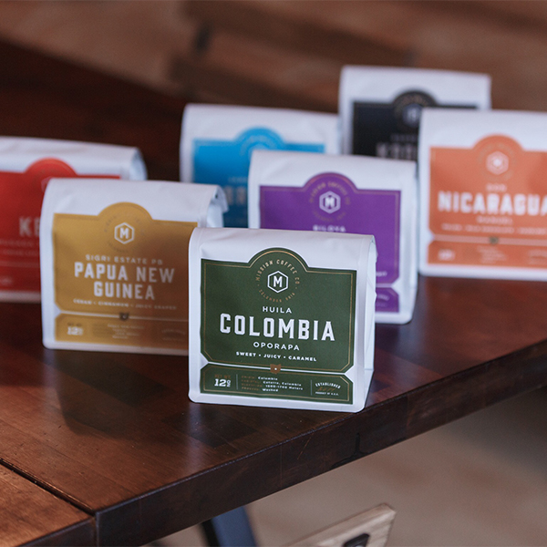 Multiple Mission Coffee bags featuring consistent gold foil stamped labels.