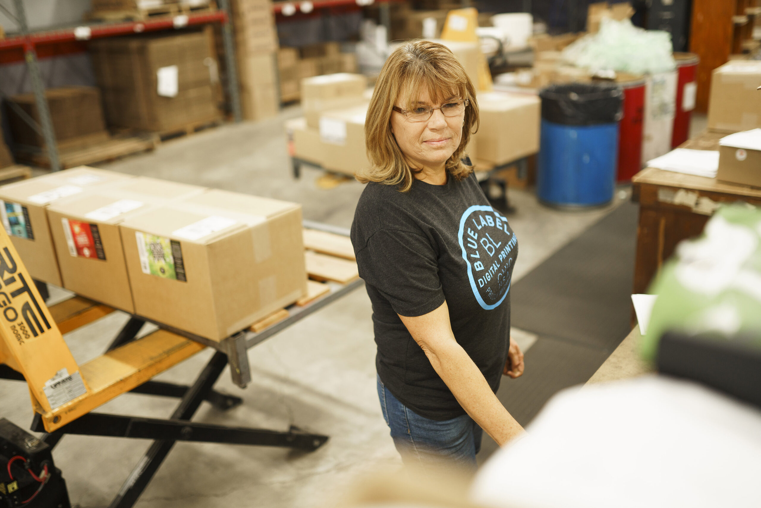 A woman carefully handling shrink sleeves for new products.