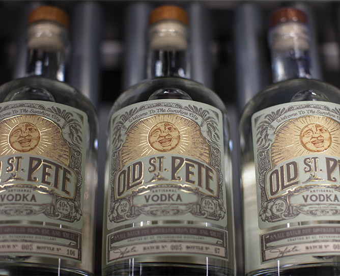 Old St. Pete Vodka bottles with embossed label decorations.