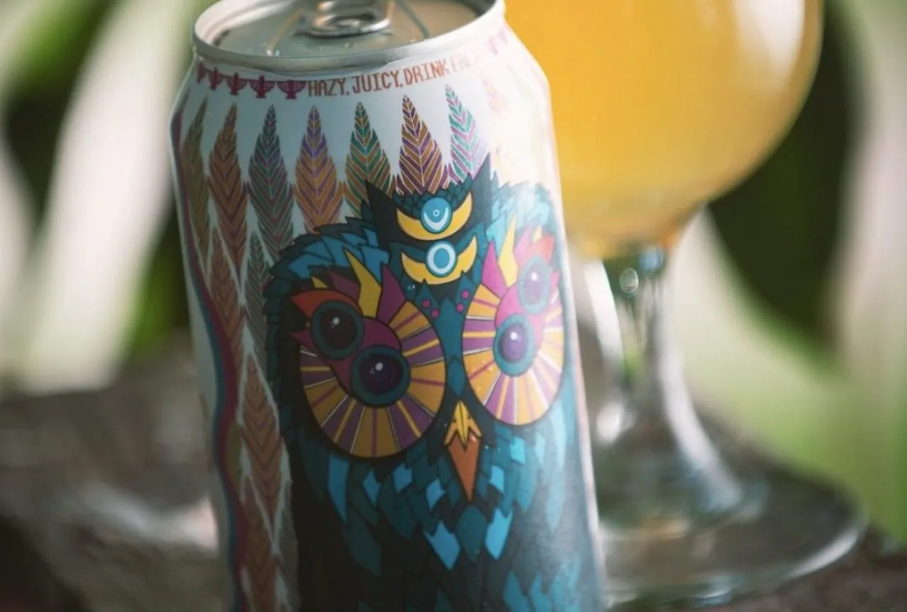 Beer can with shrink sleeve with beer glass in background